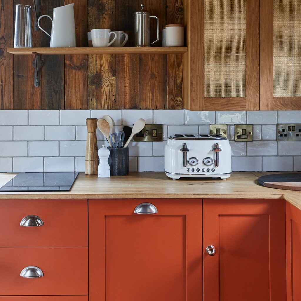 Kitchen with hand painted cabinets in deep orange shade.