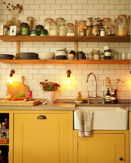 Kitchen With Yellow Cabinets Balanced With Neutral Tiles.